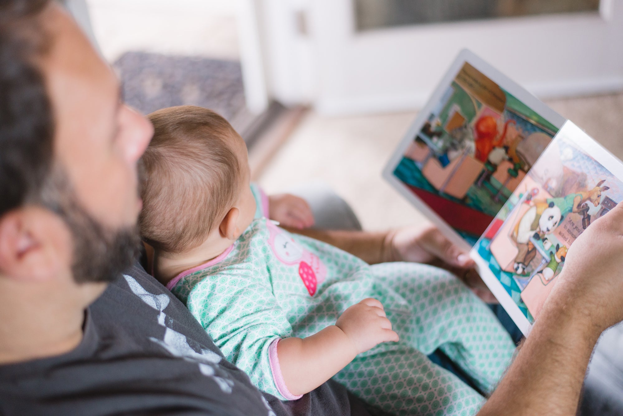Father reading to a baby on his lap