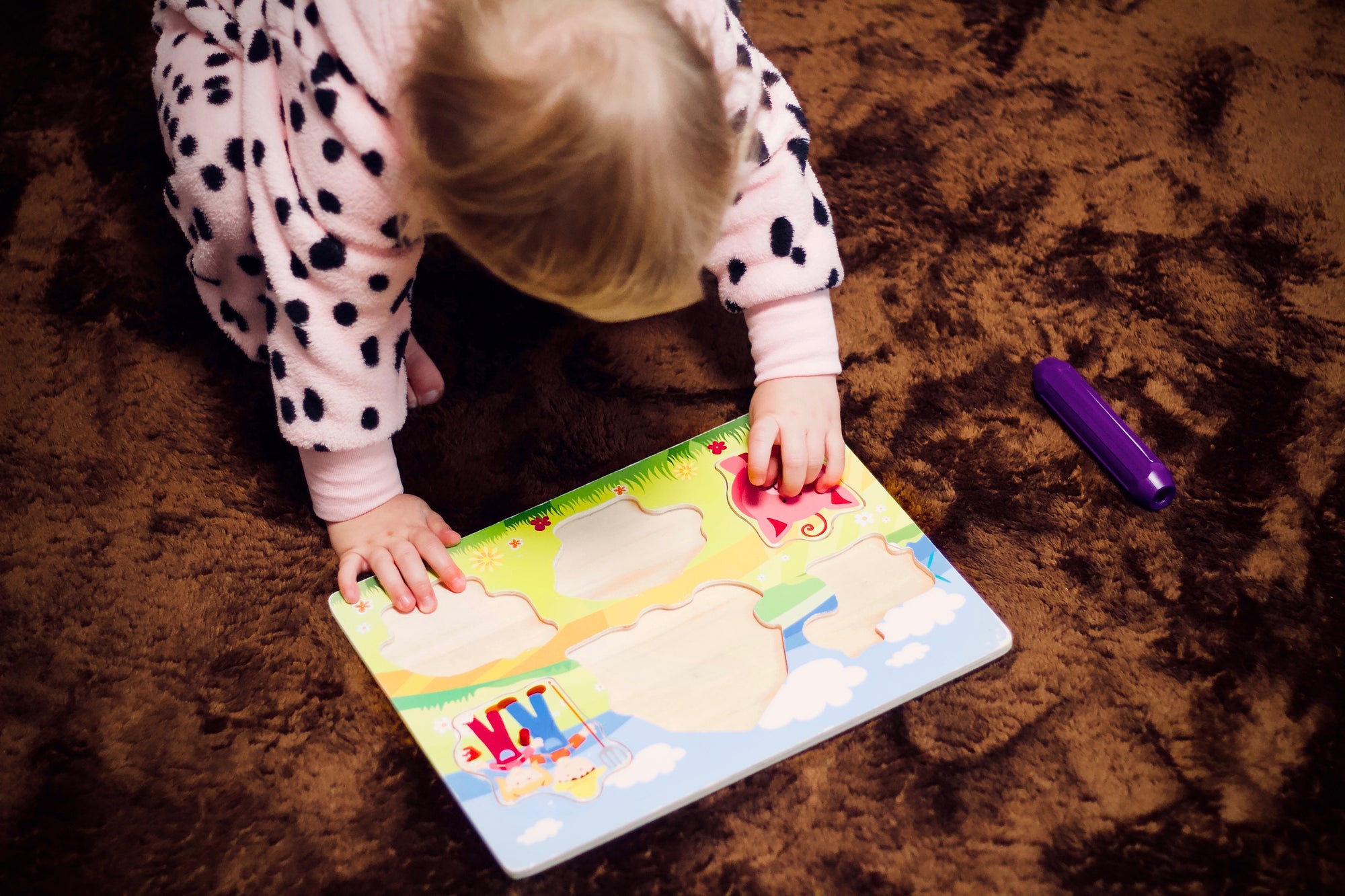 Toddler doing jigsaw as part of The Wriggler Help Them Learn Series