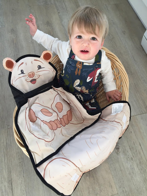 Baby holding The Wriggler changing mat for babies and toddlers who wiggle at diaper changes