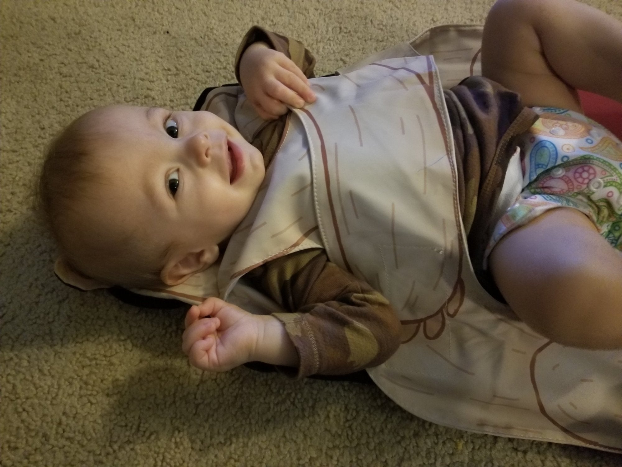 Happy toddler in The Wriggler changing mat that stops rolling over at diaper changing